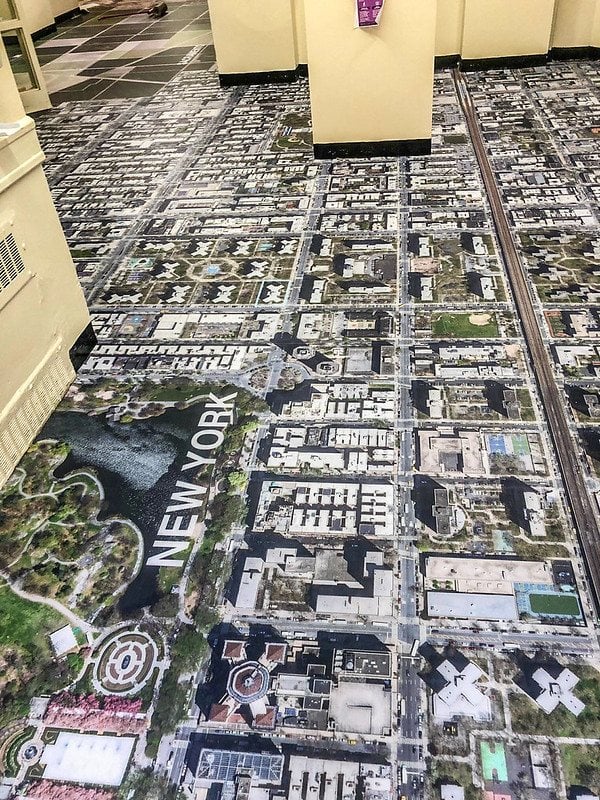 Printed aerial-map floor graphic in a public interior