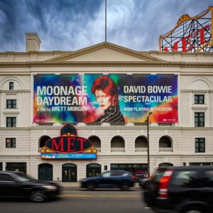 Large printed building banner mounted across a theatre facade