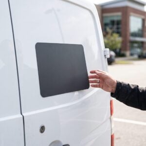 Blank magnetic vehicle sign held against the door of a white van